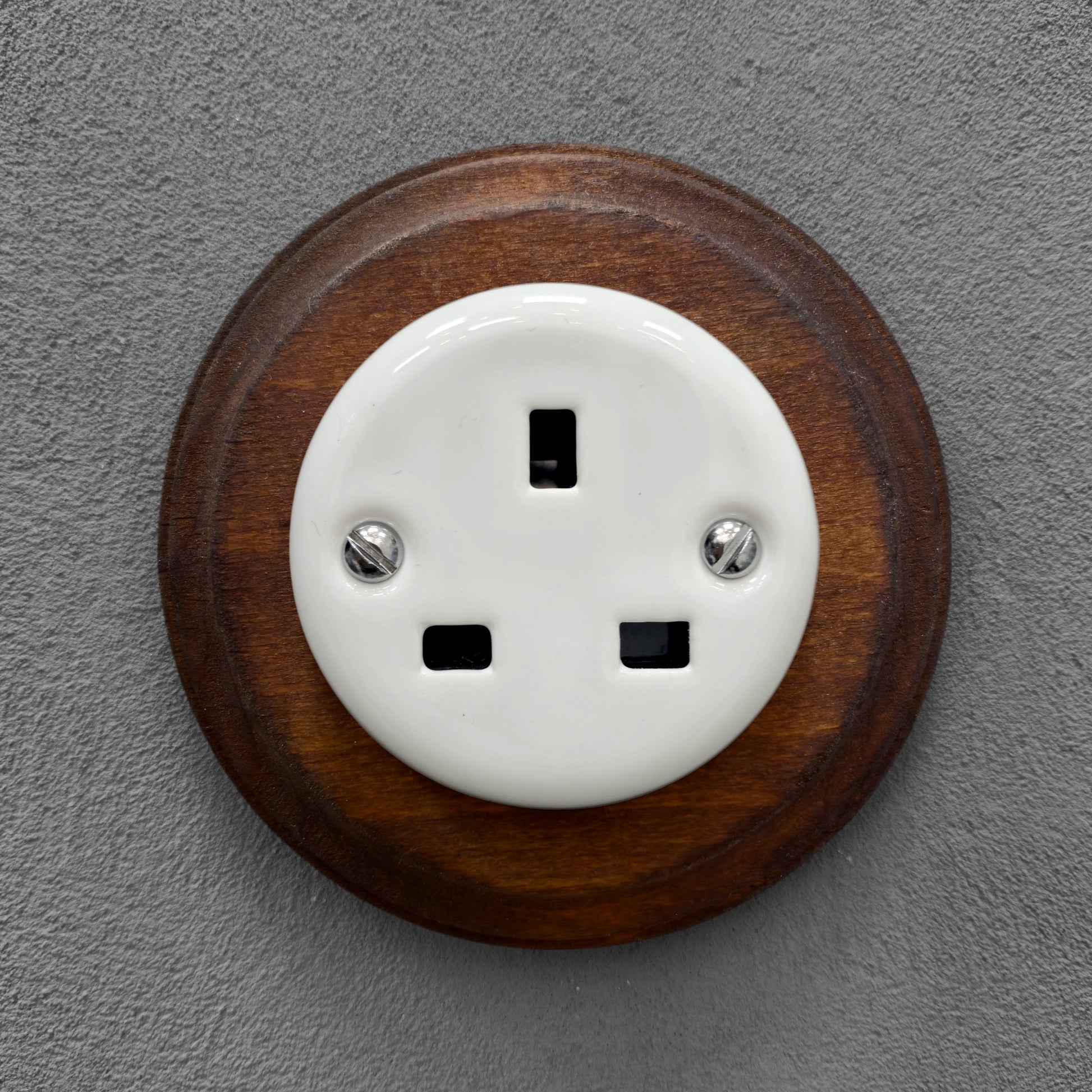 White porcelain UK Plug Socket with dark wood frame, flush-mounted, front