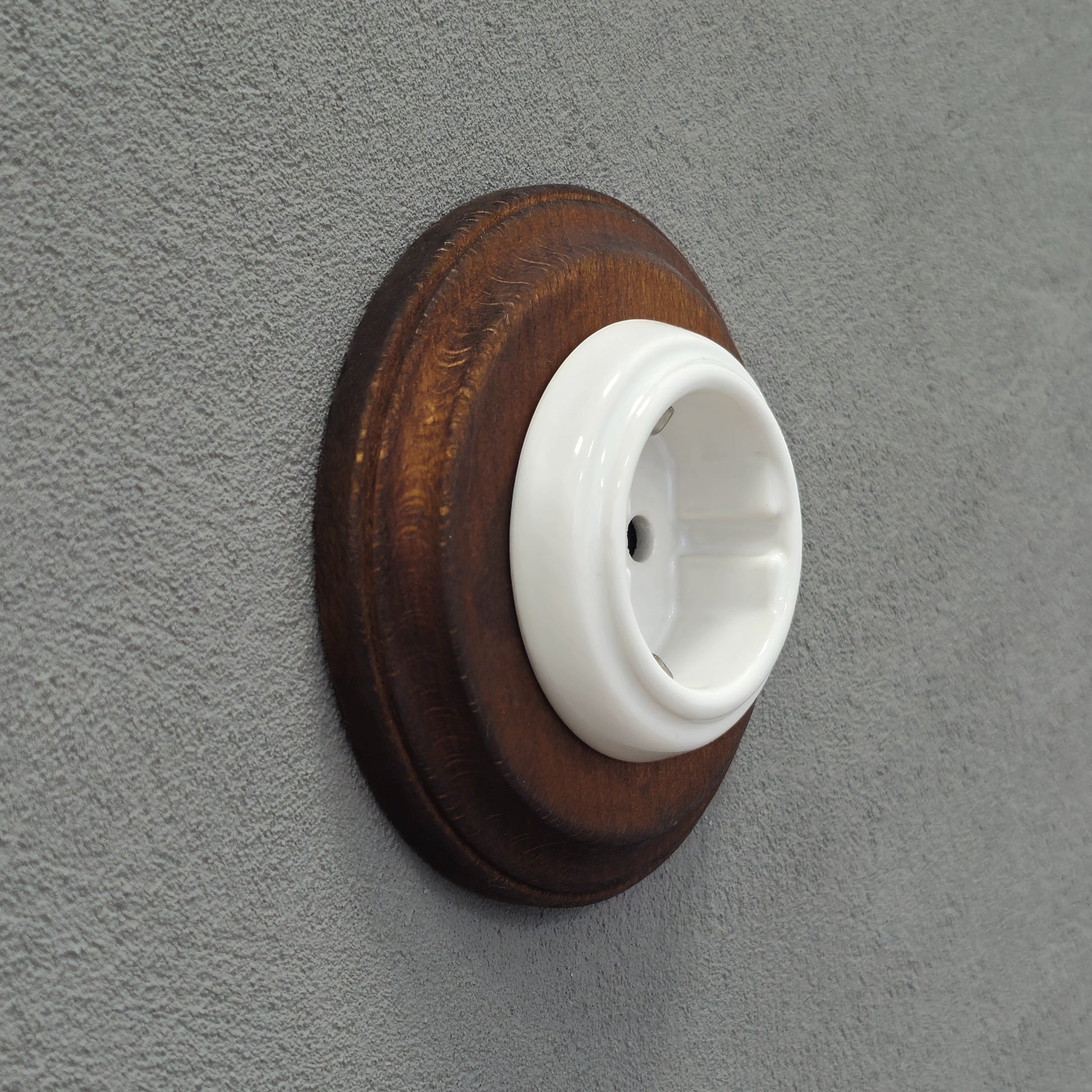 Single SCHUKO porcelain socket with dark wooden frame, white, flush-mounted, side view