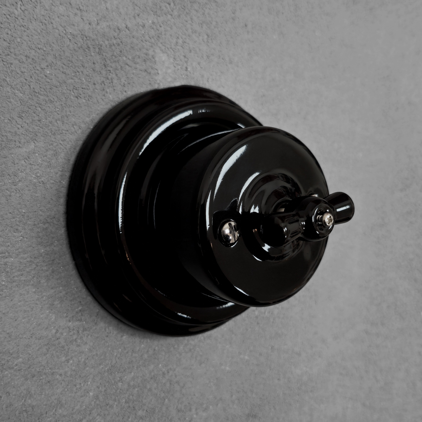 black porcelain intermediate rotary light switch, surface-mount, angled