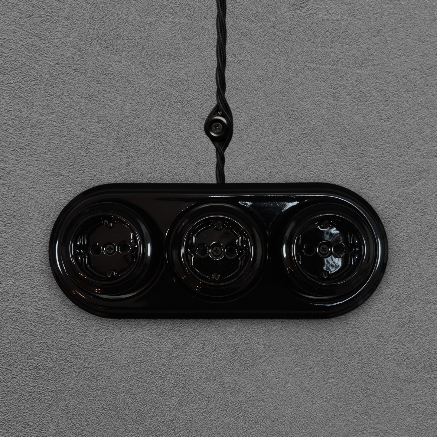 Triple SCHUKO porcelain socket, black, surface-mounted, front view