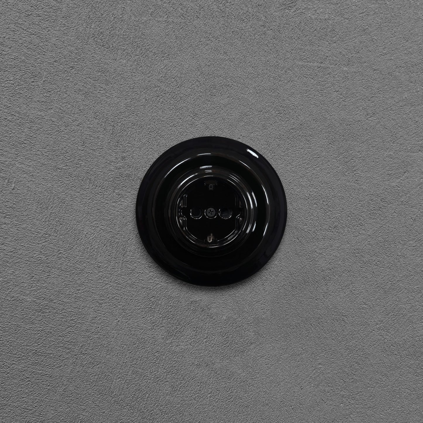 Single SCHUKO porcelain socket, black, flush-mounted, front view