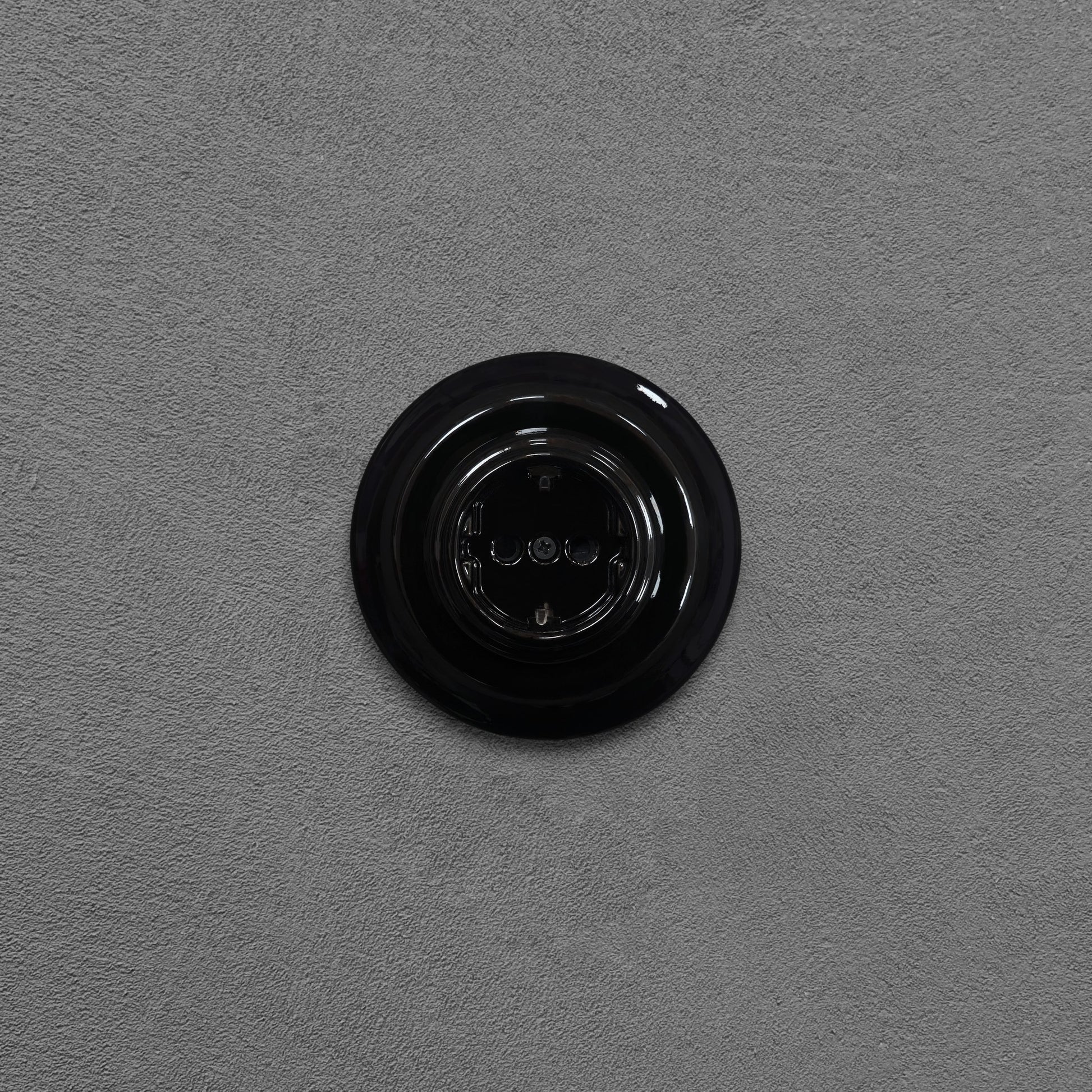 Single SCHUKO porcelain socket, black, flush-mounted, front view