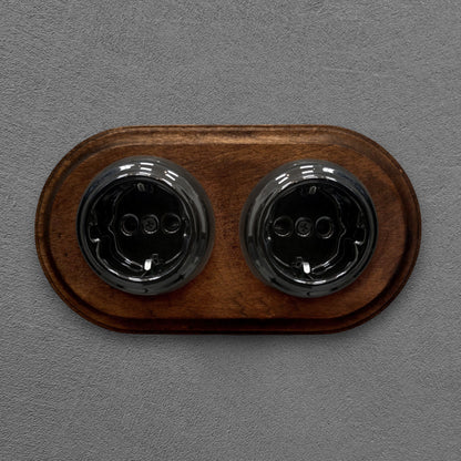 Double SCHUKO porcelain socket with dark wooden frame, black, flush-mounted, front view
