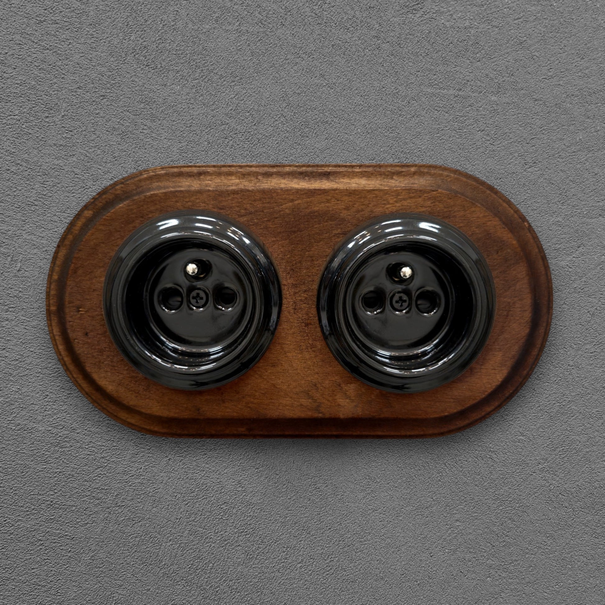 Double black French porcelain socket with dark wood frame, flush-mount, front